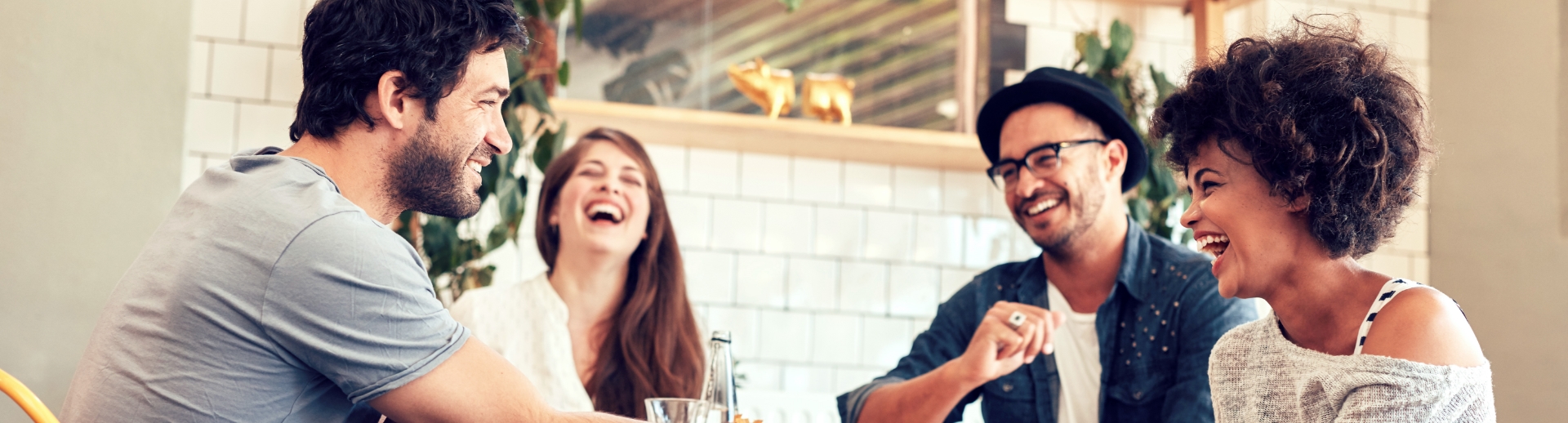 Group of people engaged in conversation at a dining table.